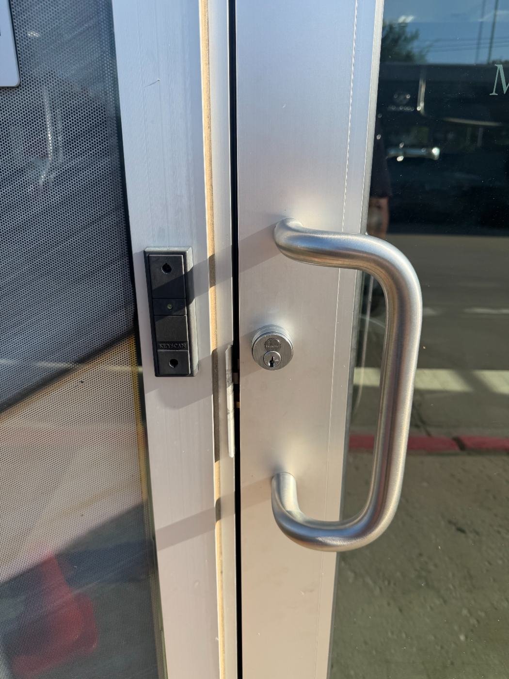 Keyscan proximity card reader mounted beside a commercial glass storefront door in Dallas
