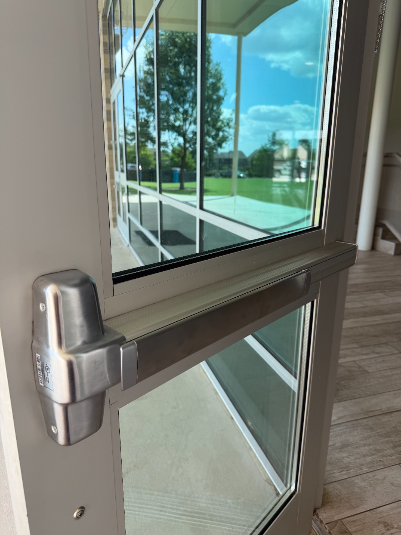 Commercial push bar and panic bar installation on a glass door in Dallas TX
